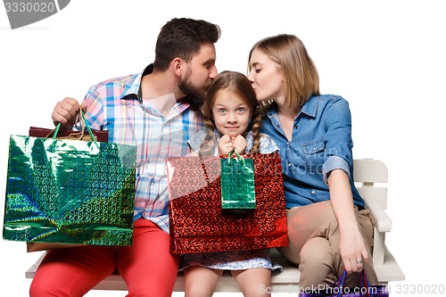 Image of Happy family with shopping bags sitting at studio 