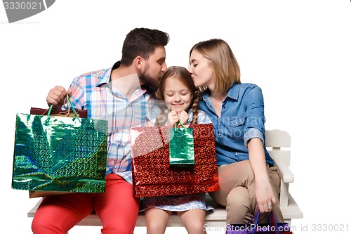 Image of Happy family with shopping bags sitting at studio 