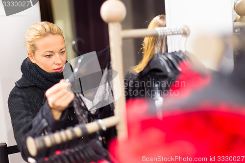 Image of Beautiful woman shopping in clothing store.