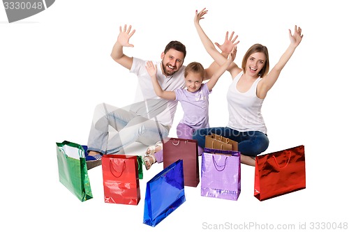 Image of Happy family with shopping bags sitting at studio 