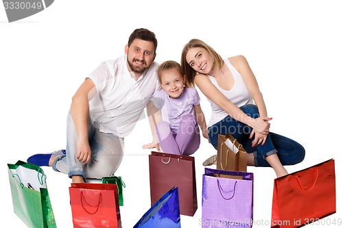 Image of Happy family with shopping bags sitting at studio 