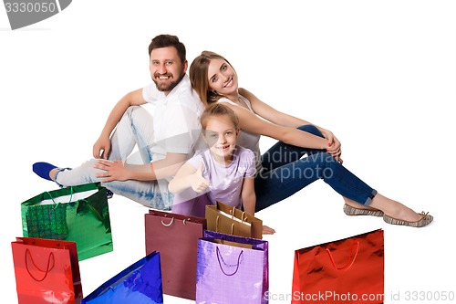 Image of Happy family with shopping bags sitting at studio 