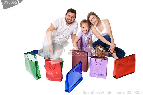 Image of Happy family with shopping bags sitting at studio 