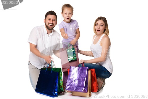 Image of Happy family with shopping bags sitting at studio 