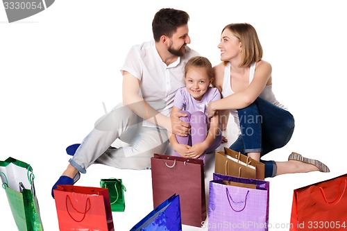 Image of Happy family with shopping bags sitting at studio 