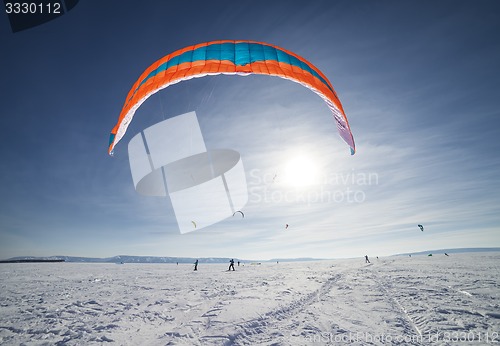 Image of Kiteboarder with blue kite on the snow