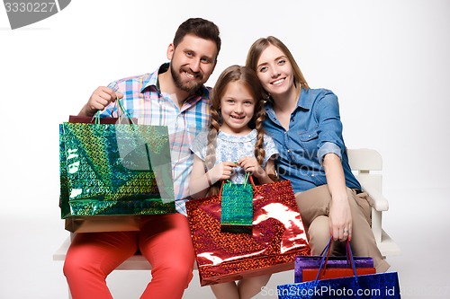 Image of Happy family with shopping bags sitting at studio 