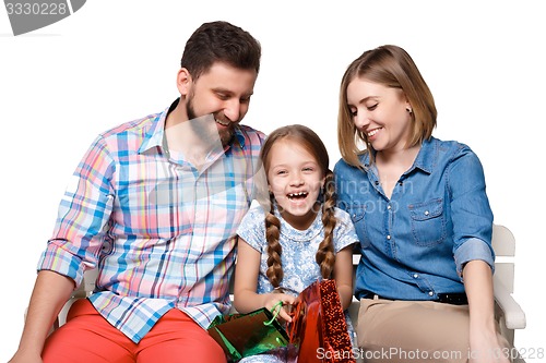 Image of Happy family with shopping bags sitting at studio 