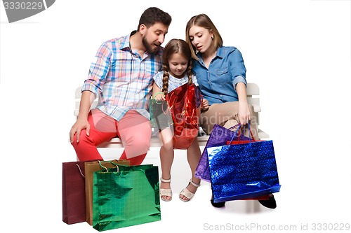 Image of Happy family with shopping bags sitting at studio 