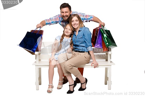 Image of Happy family with shopping bags sitting at studio 