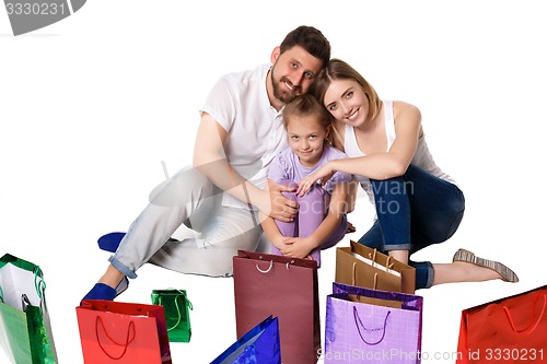 Image of Happy family with shopping bags sitting at studio 