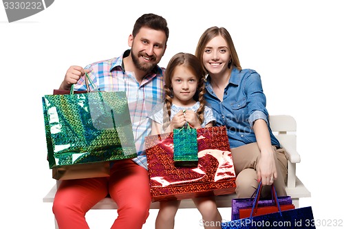 Image of Happy family with shopping bags sitting at studio 