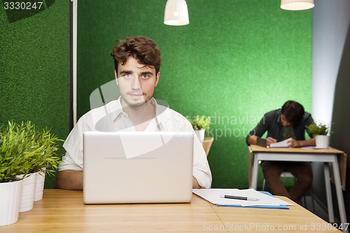 Image of Young Businessman With Laptop In Lobby