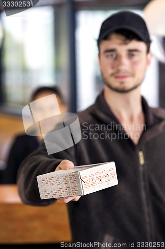 Image of Delivery Man Giving Parcel In Office