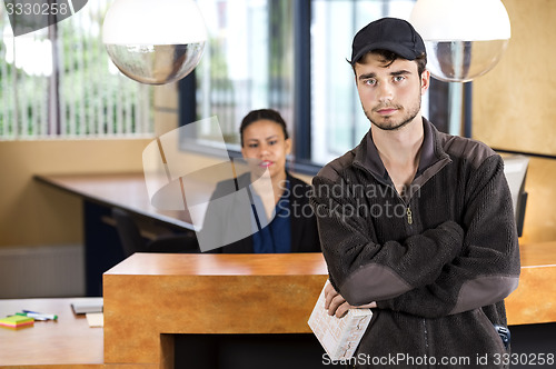 Image of Delivery Man Standing At Office Reception