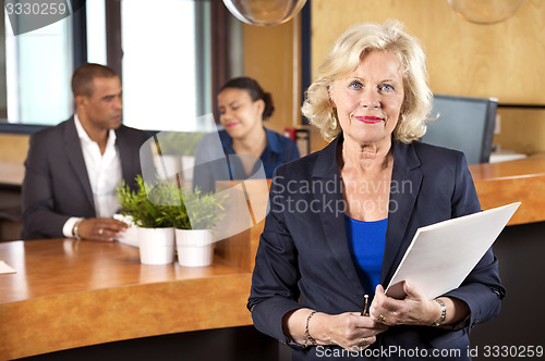 Image of Businesswoman Holding File At Reception Counter