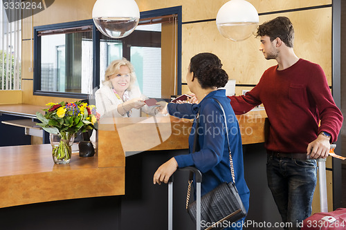 Image of Couple Giving Passports To Receptionist