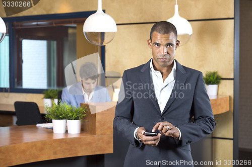 Image of Businesswoman Holding Cellphone At Reception Desk