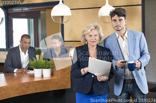 Image of Businesspeople Standing At Reception Counter