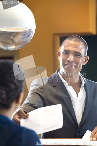 Image of Businessman Giving Paper To Receptionist