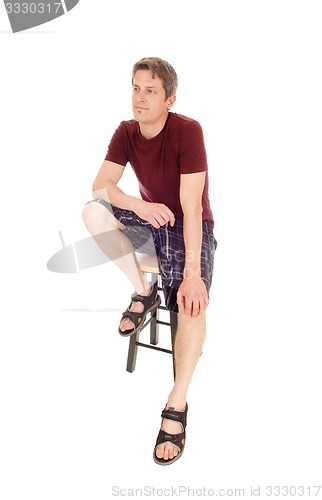 Image of Young man in shorts sitting.