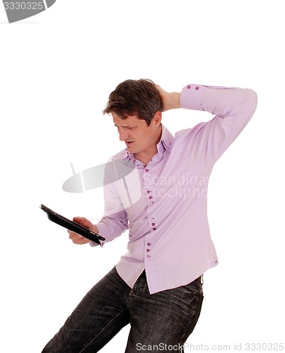 Image of Man wondering what is on his tablet pc.