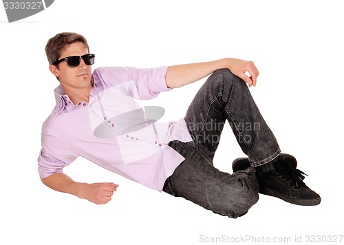 Image of Man lying on floor, relaxing.