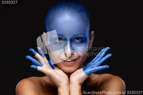 Image of Portrait of a woman who is posing covered with blue paint