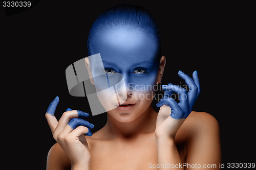 Image of Portrait of a woman who is posing covered with blue paint