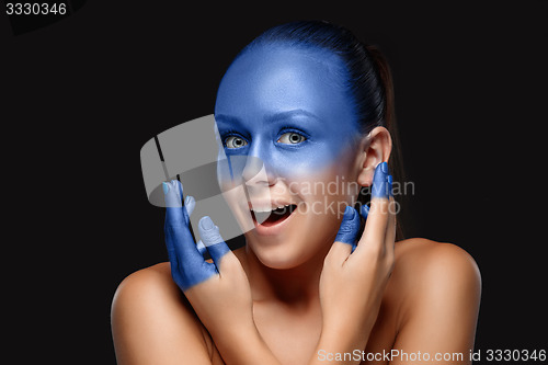 Image of Portrait of a woman who is posing covered with blue paint