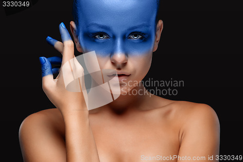 Image of Portrait of a woman who is posing covered with blue paint