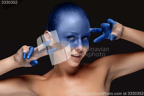 Image of Portrait of a woman who is posing covered with blue paint