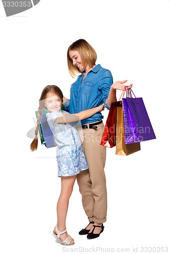 Image of Happy  mother and daughter with shopping bags standing at studio 