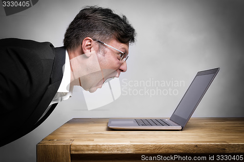 Image of Man screaming at laptop