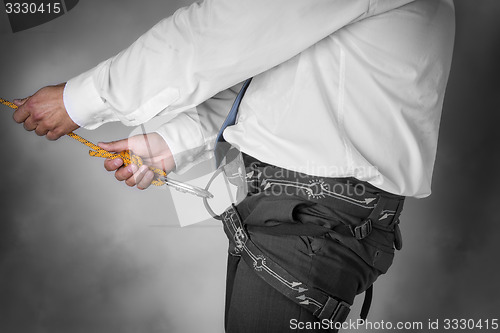 Image of businessman on climbing rope