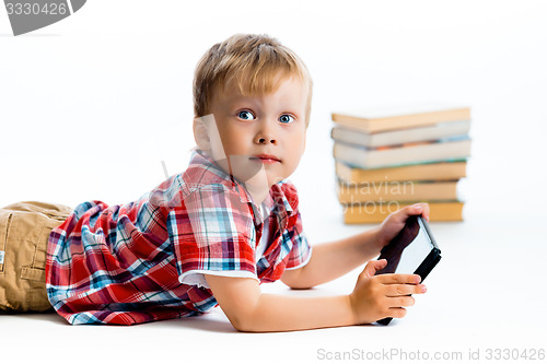 Image of boy in a plaid shirt with a tablet computer against