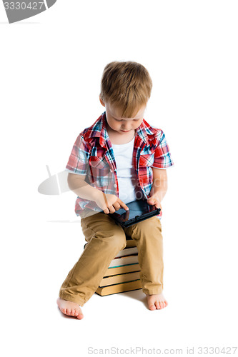 Image of boy in a plaid shirt with a tablet computer