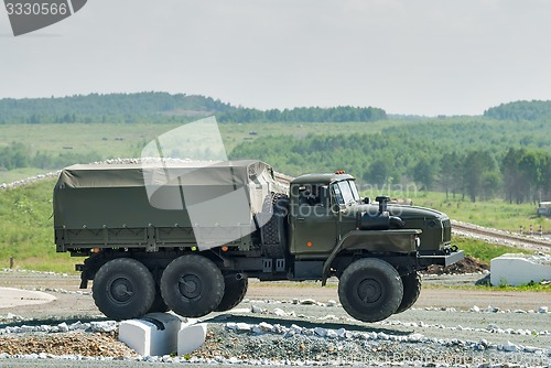 Image of Army truck URAL-4320 jumps through obstacle