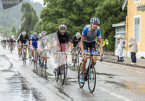 Image of The Peloton Riding in the Rain - Tour de France 2014