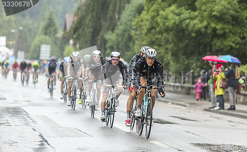 Image of The Peloton Riding in the Rain - Tour de France 2014