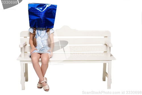 Image of Happy girl with shopping bags sitting at studio 