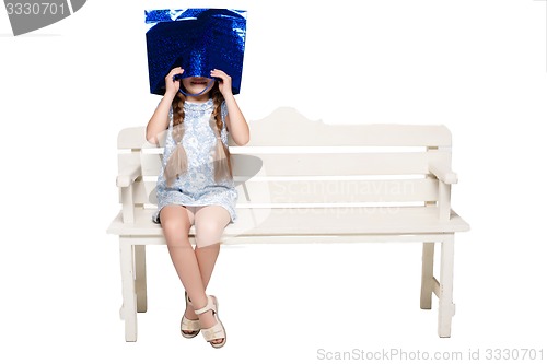 Image of Happy girl with shopping bags sitting at studio 