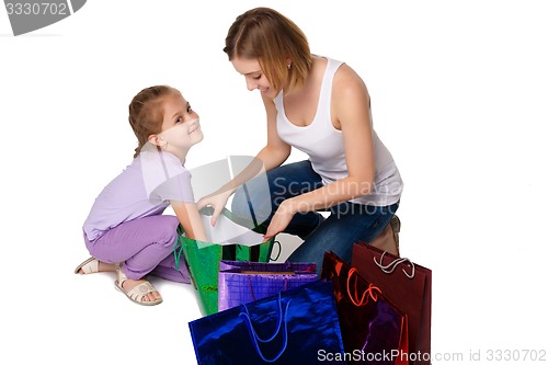 Image of Happy a mother and daughter with shopping bags sitting at studio 