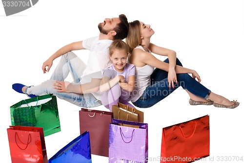 Image of Happy family with shopping bags sitting at studio 
