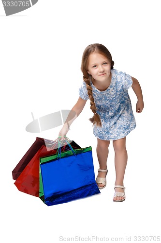 Image of Happy girl with shopping bags standing at studio 
