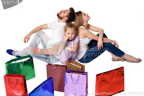 Image of Happy family with shopping bags sitting at studio 