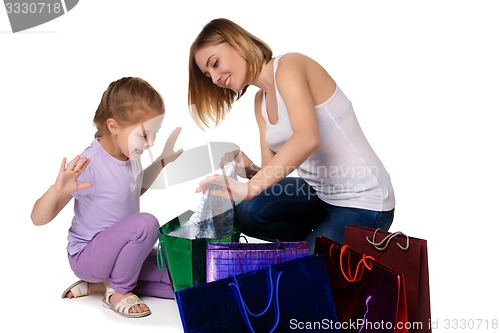 Image of Happy a mother and daughter with shopping bags sitting at studio 