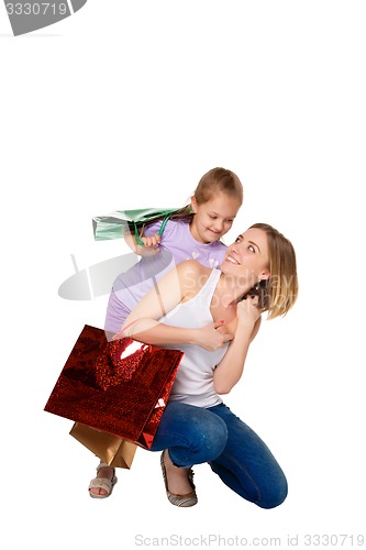 Image of Happy a mother and daughter with shopping bags standing at studio 