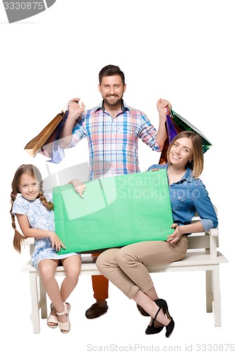 Image of Happy family with shopping bags sitting at studio 