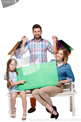 Image of Happy family with shopping bags sitting at studio 